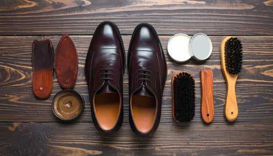 A well-organized shoe care kit with brushes, polishes, conditioners, and shoe trees, next to a pair of classic leather shoes that look well-maintained.